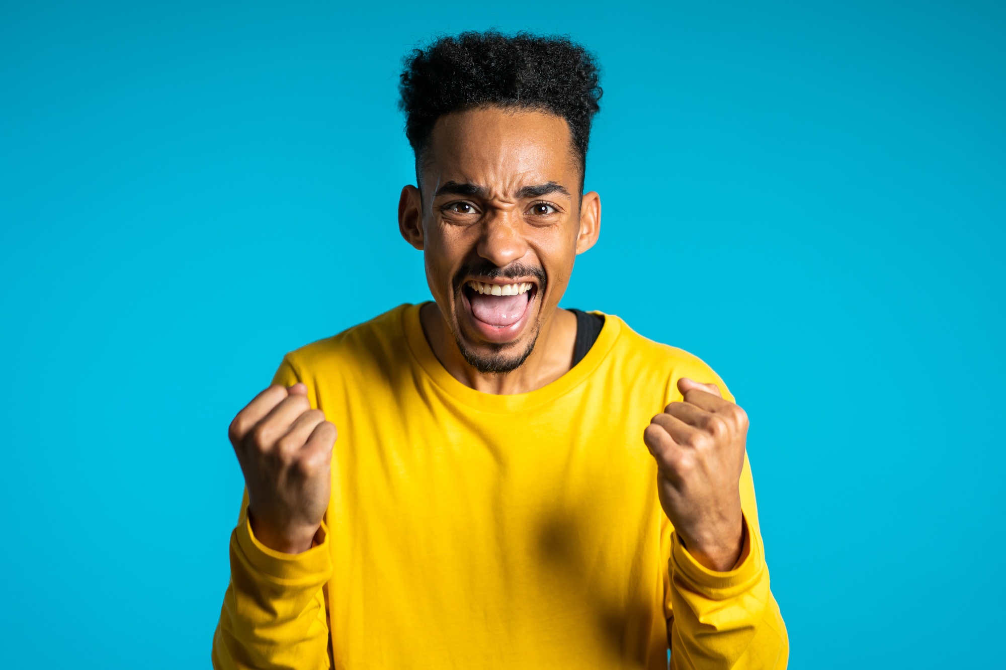 Man screaming, loudly shouting, shows yeah gesture of victory,he achieved result, goals.